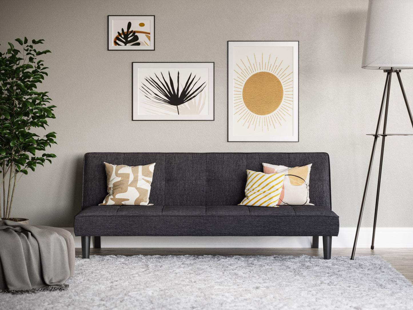Dark grey futon sofa bed with tufted cushions, wooden legs, and convertible design for modern living rooms.