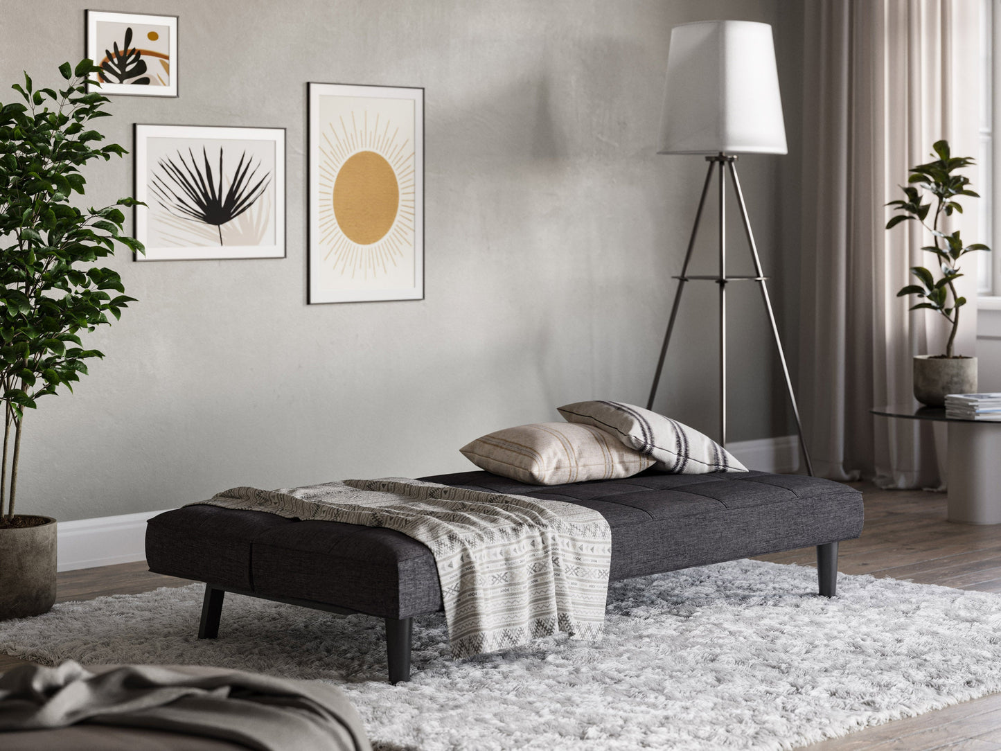 Dark grey futon sofa bed with wooden legs and tufted cushions, convertible design for modern living rooms.