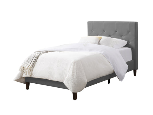 Light grey button tufted twin bed with wooden legs and upholstered headboard.