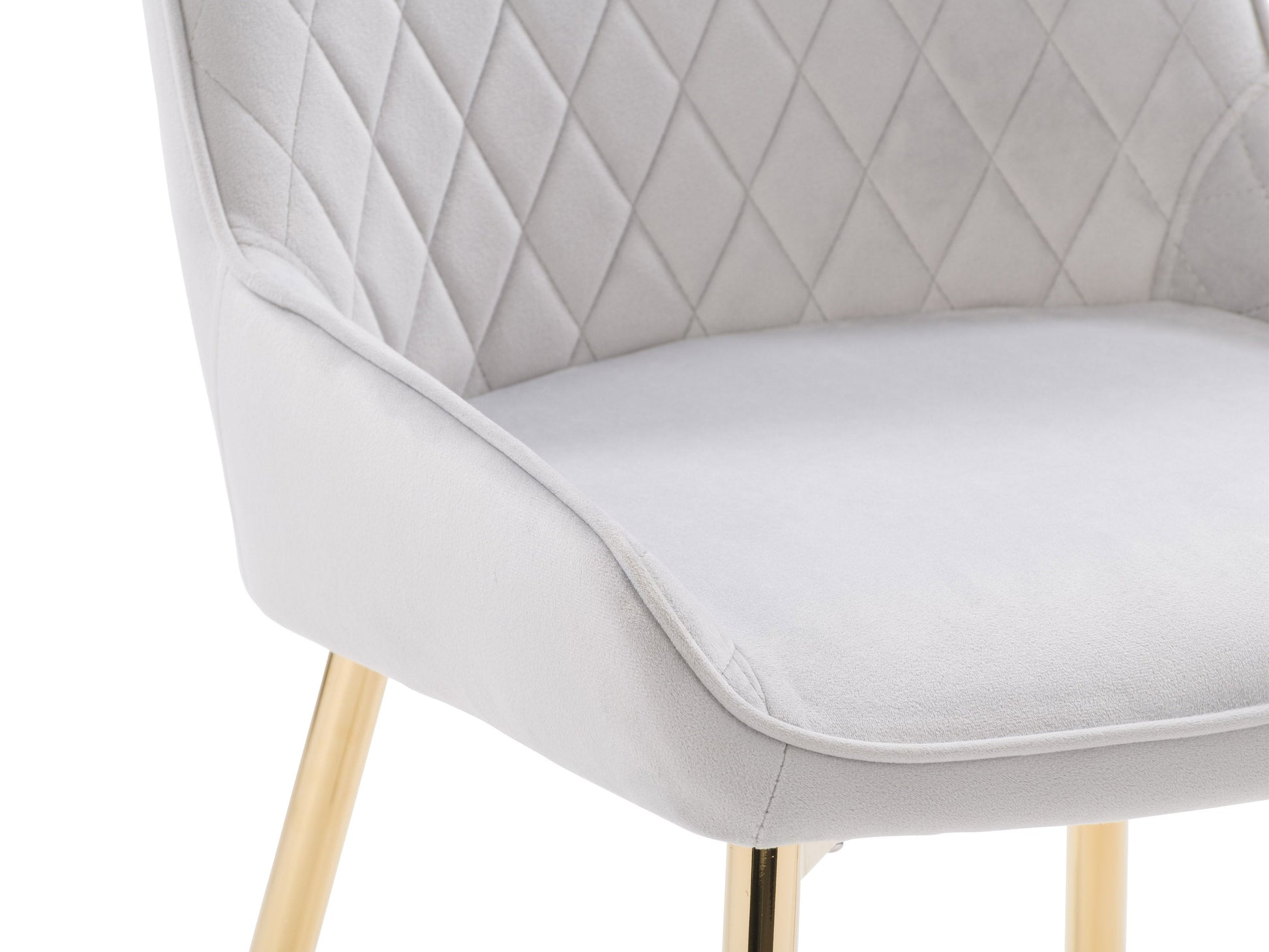 Light grey velvet dining chairs set with gold metal legs, luxurious upholstery, and a contemporary design.