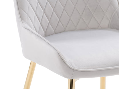 Light grey velvet dining chairs set with gold metal legs, luxurious upholstery, and a contemporary design.
