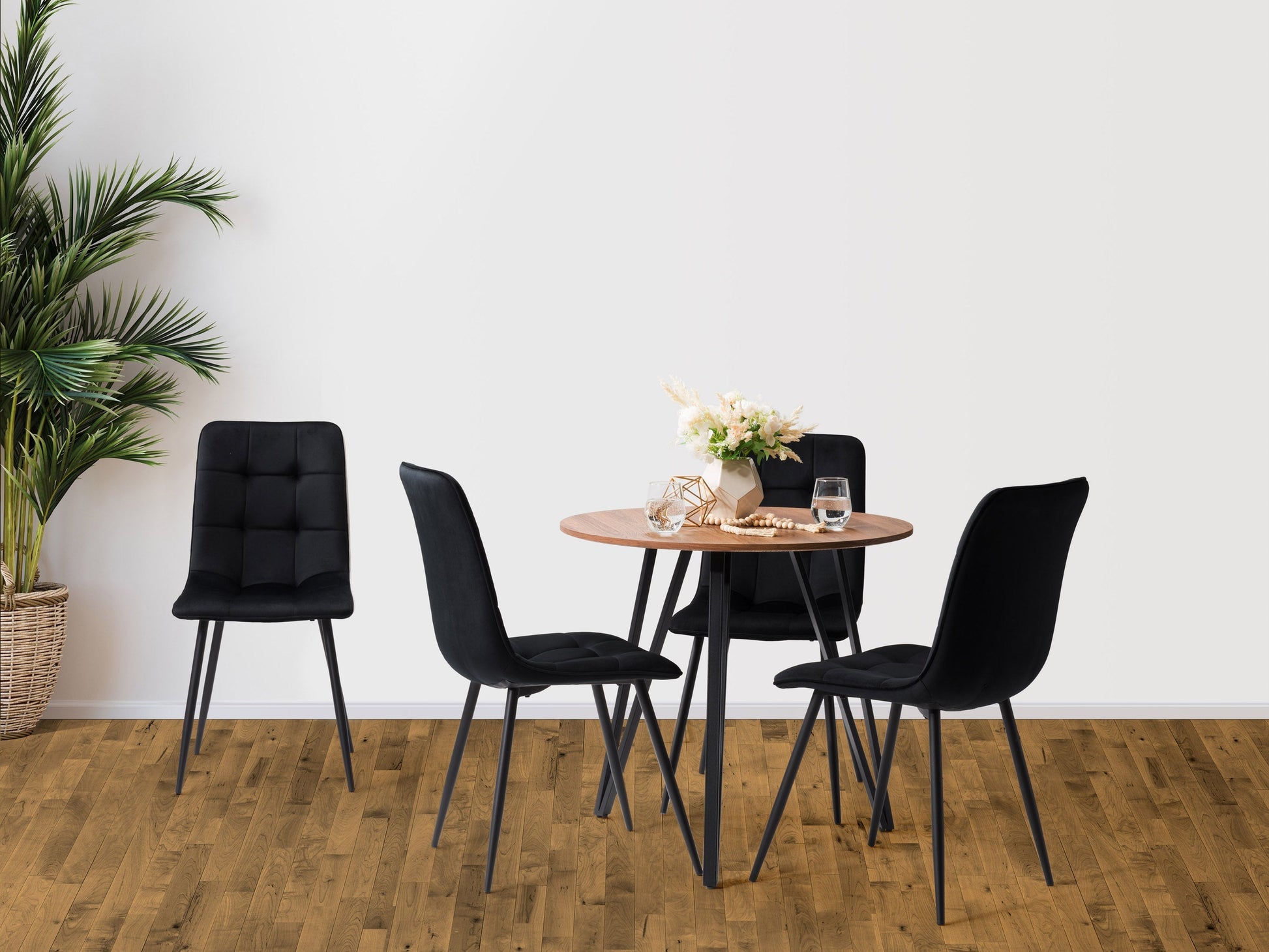Round black dining table set with four chairs, modern design, wooden legs, sleek finish.