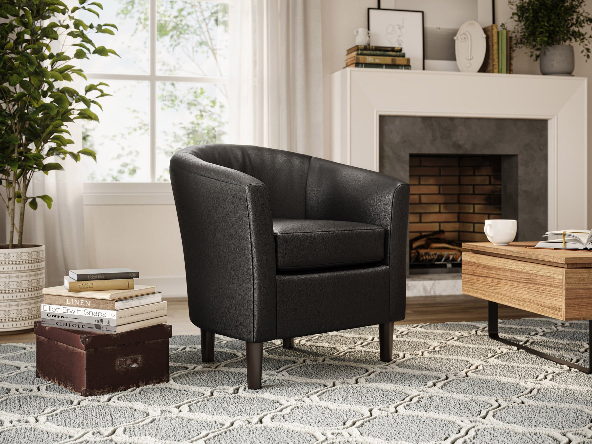 Black vegan leather barrel chair with gold metal legs and tufted backrest.