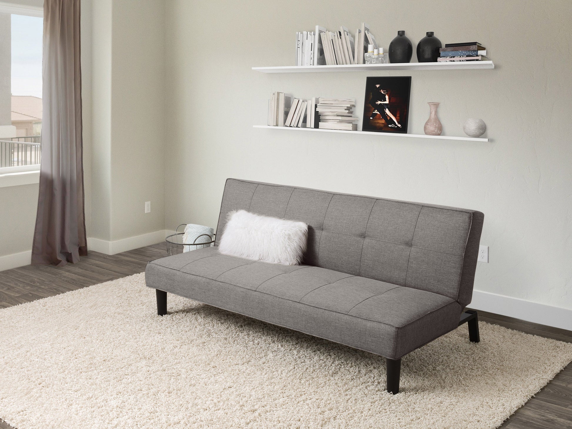 Light grey futon sofa bed with tufted cushions, wooden legs, and convertible design for modern living rooms.