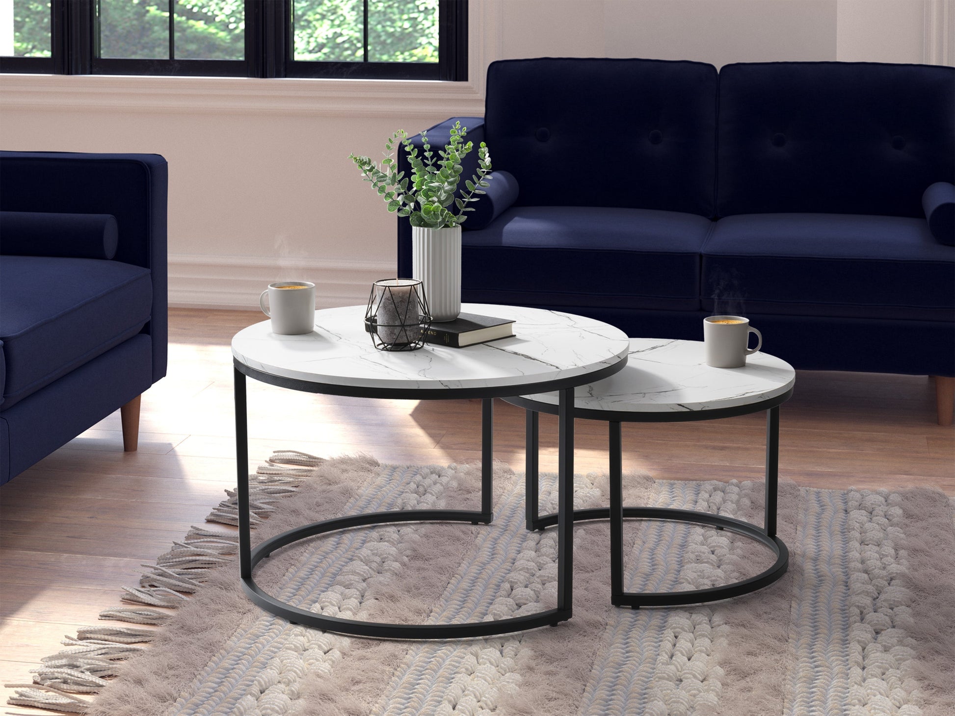 Round nesting coffee tables with white marble tops and gold metal frames, elegant and versatile design.