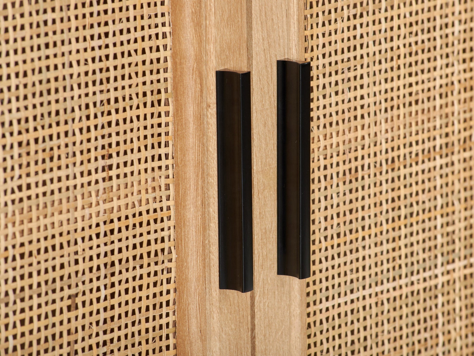 Light wood dining accent cabinet with sleek black metal handles and four spacious drawers.