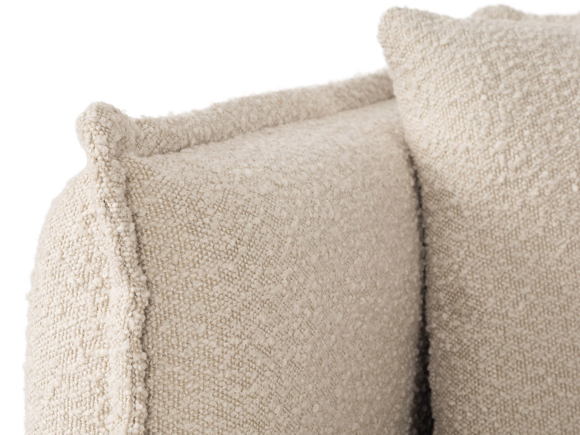 Boucle sofa with cream upholstery, curved design, and wooden legs, perfect for modern living rooms.