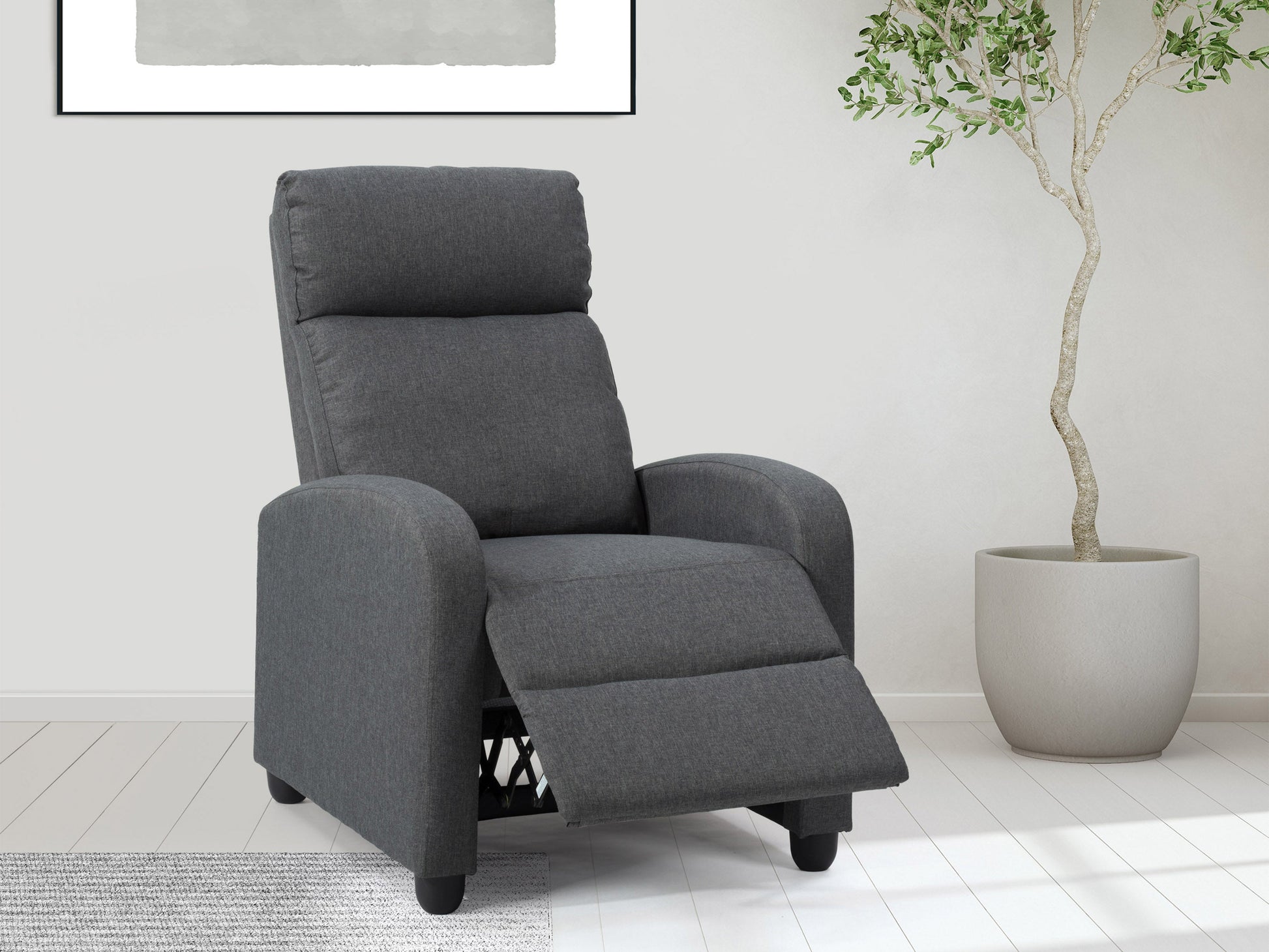 Dark grey push back recliner with tufted backrest, wooden legs, and soft fabric upholstery.