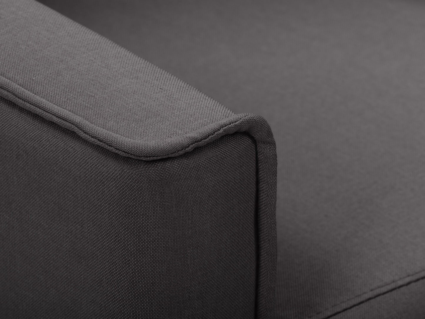Dark grey mid-century recliner with wooden legs, tufted backrest, and soft fabric upholstery.