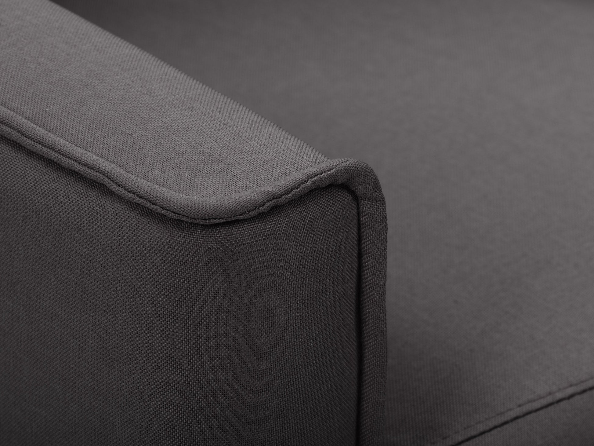 Dark grey mid-century recliner with wooden legs, tufted backrest, and soft fabric upholstery.