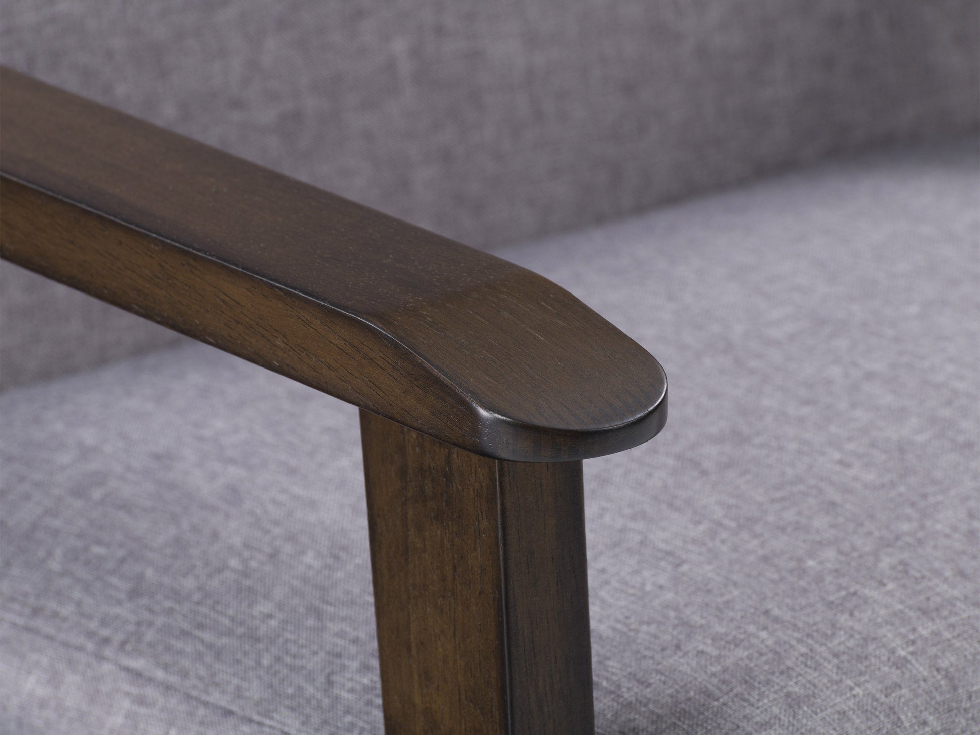 Grey wood accent chair with cushioned seat, slatted backrest, and sleek armrests for modern living rooms.