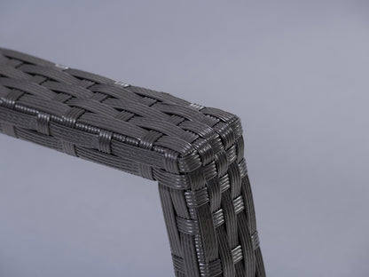 Black and grey wicker outdoor rocking chair with cushioned seat and backrest, perfect for patio relaxation.