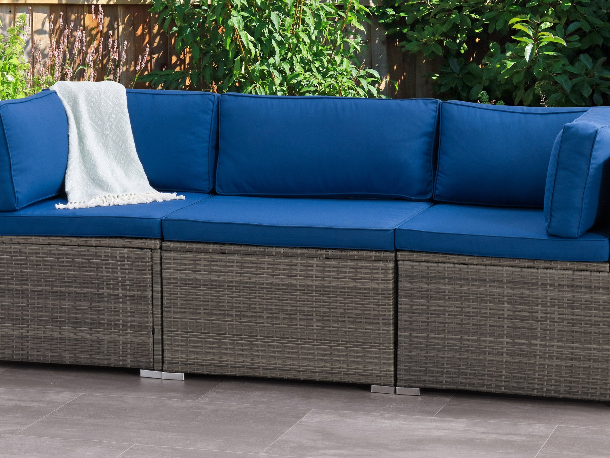 Wicker patio chair with cushioned seat and backrest in neutral tones, featuring a sturdy metal frame, woven rattan texture, and armrests, perfect for outdoor lounging and garden decor.
