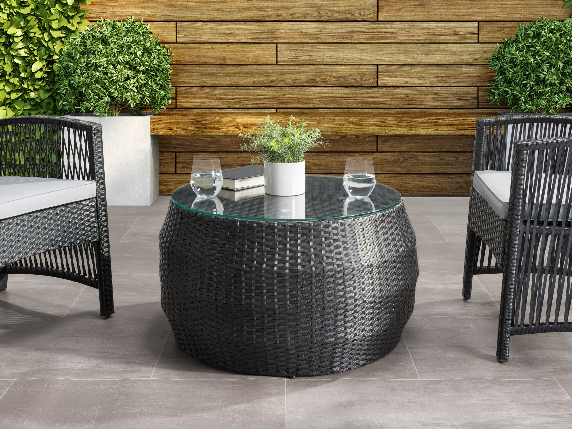 Round wicker patio coffee table with glass top, featuring intricate woven design in natural brown tones, sturdy legs, and weather-resistant materials. Ideal for outdoor use on patios and garden spaces.