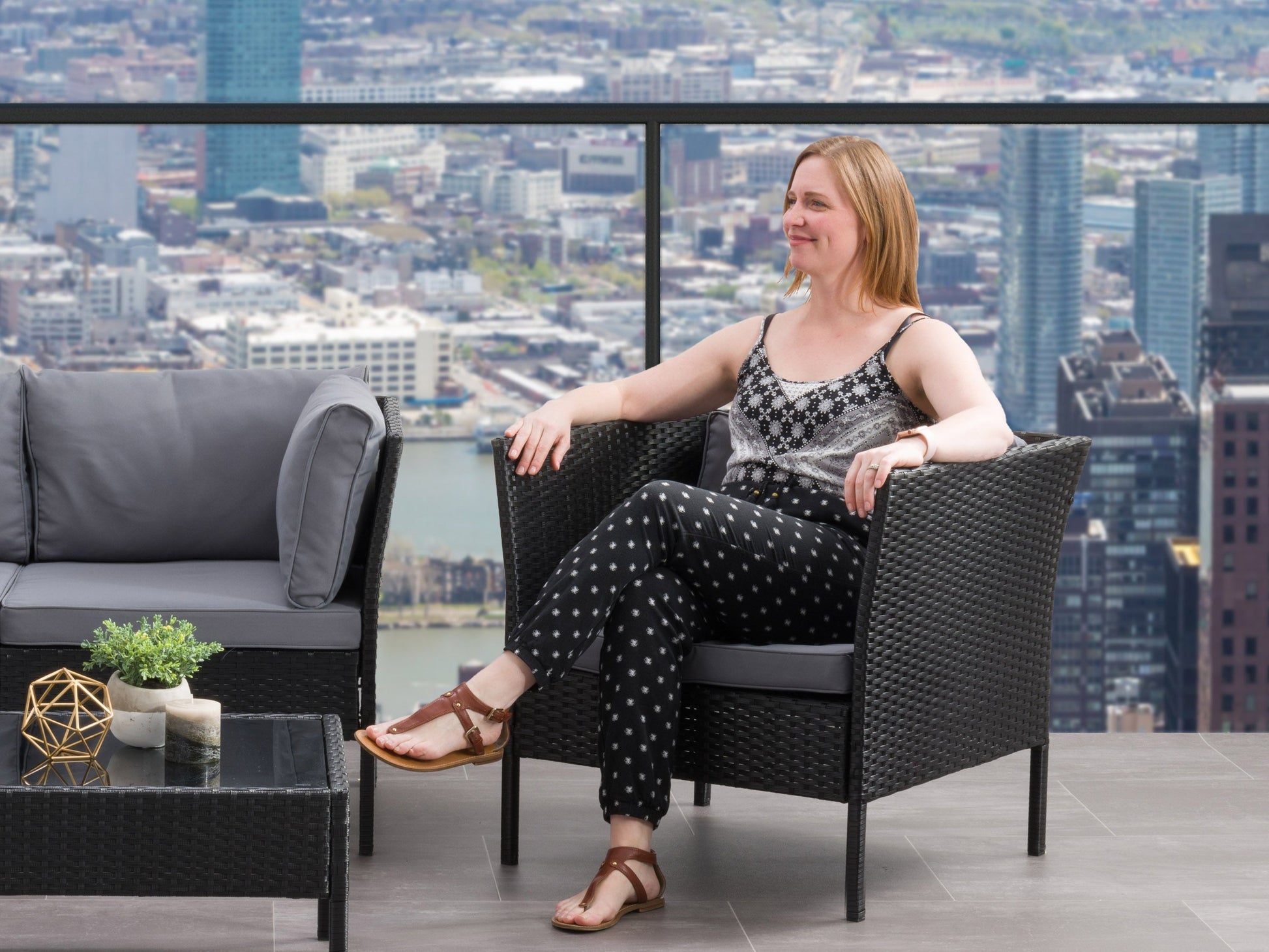 Black and grey patio armchair with cushioned seat, metal frame, and modern design.