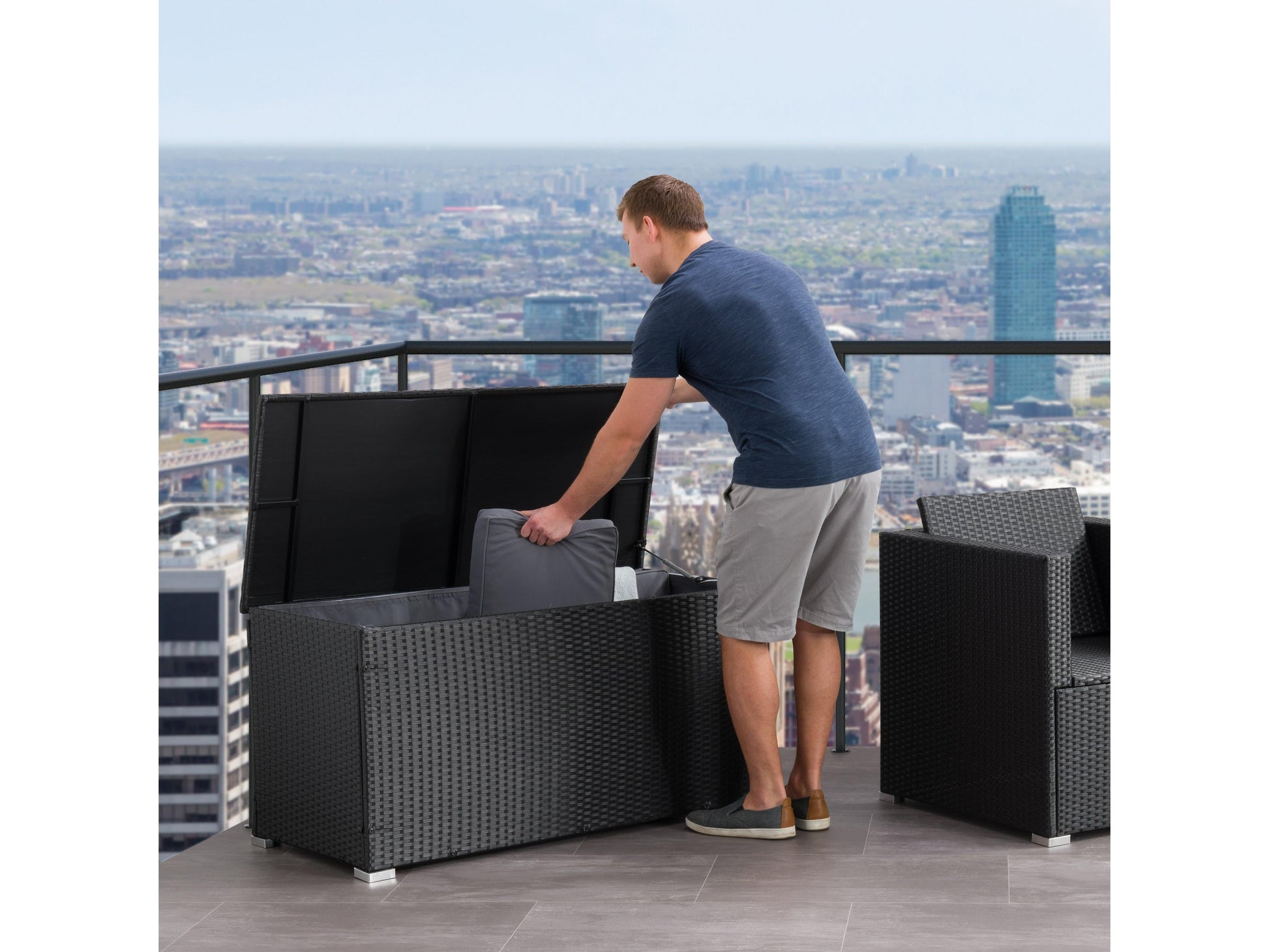 Outdoor patio cushion storage box, grey wicker design, weather-resistant, hinged lid, spacious interior.