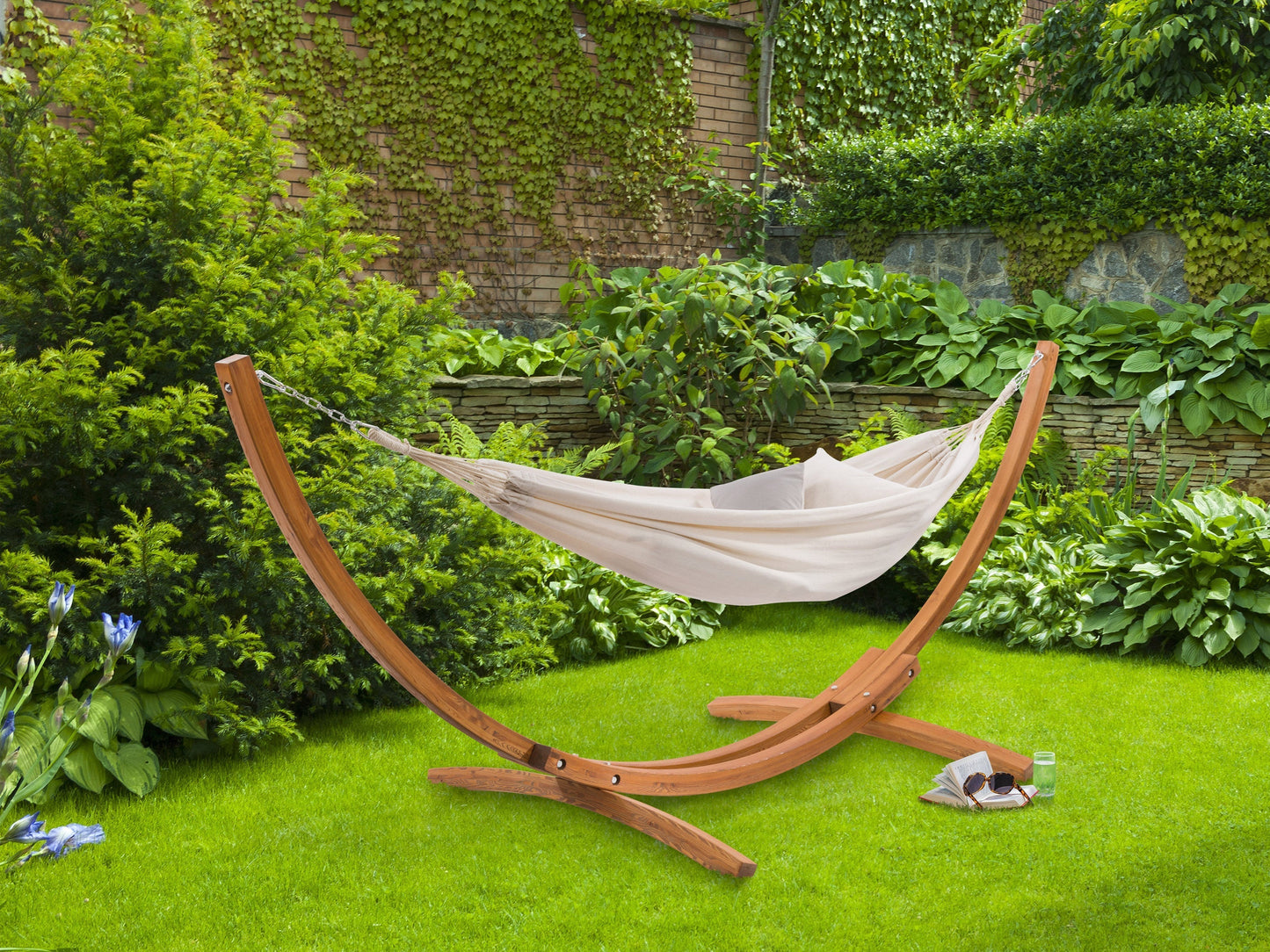 Beige hammock with wooden stand, perfect for patios, featuring a durable fabric and stylish curved wood design.