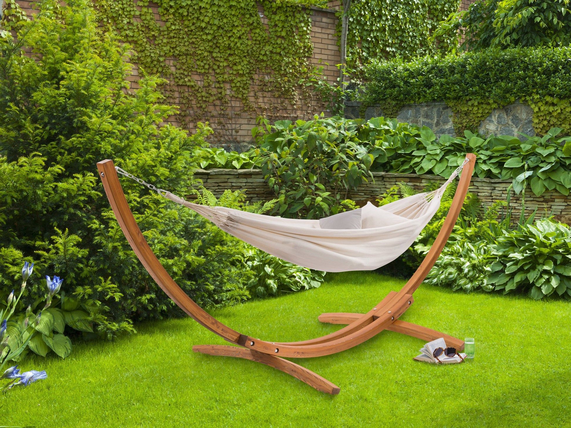 Beige hammock with wooden stand, perfect for patios, featuring a durable fabric and stylish curved wood design.